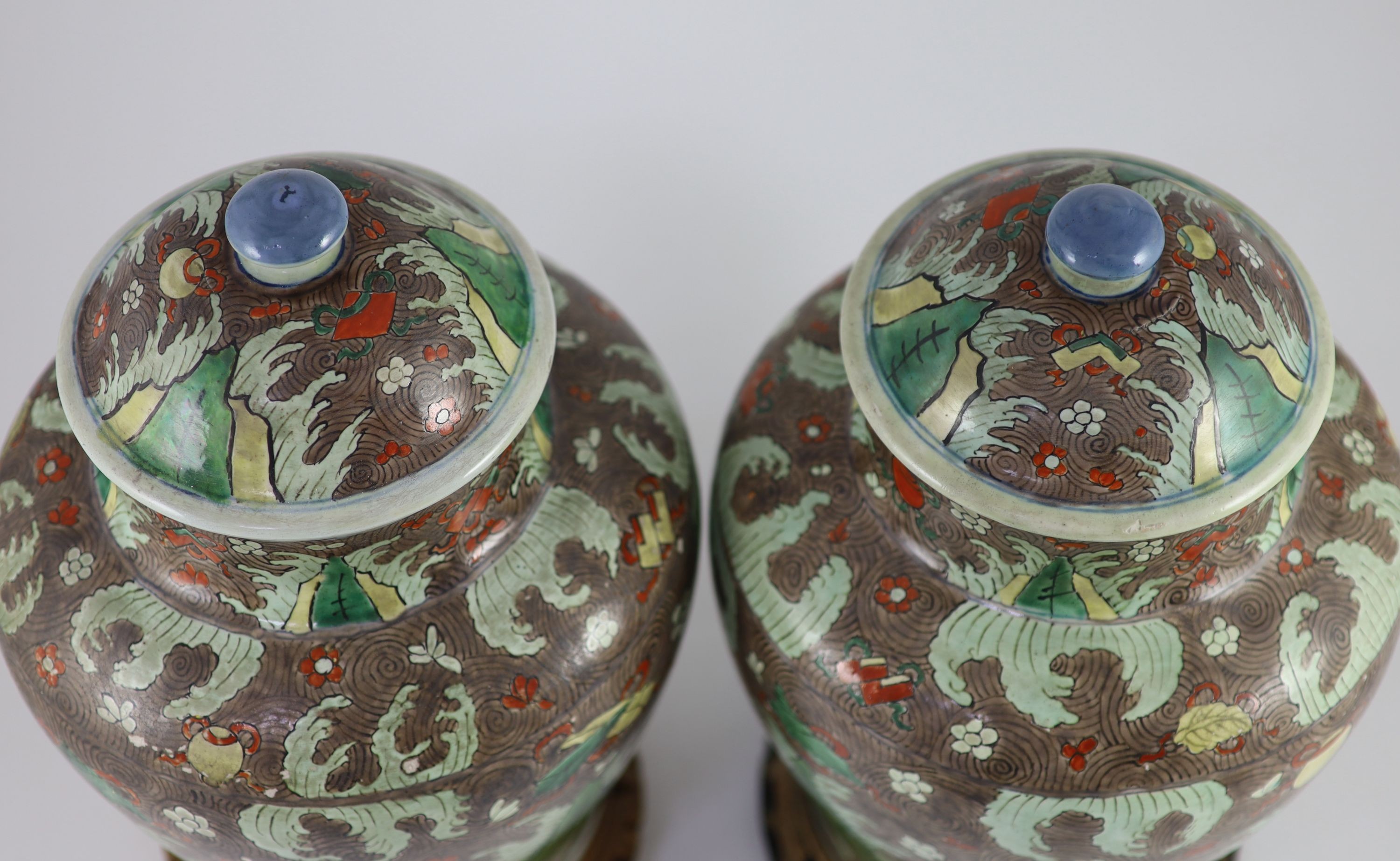 A pair of Chinese enamelled porcelain jars and covers, in Transitional style, 34cm high, wood stands